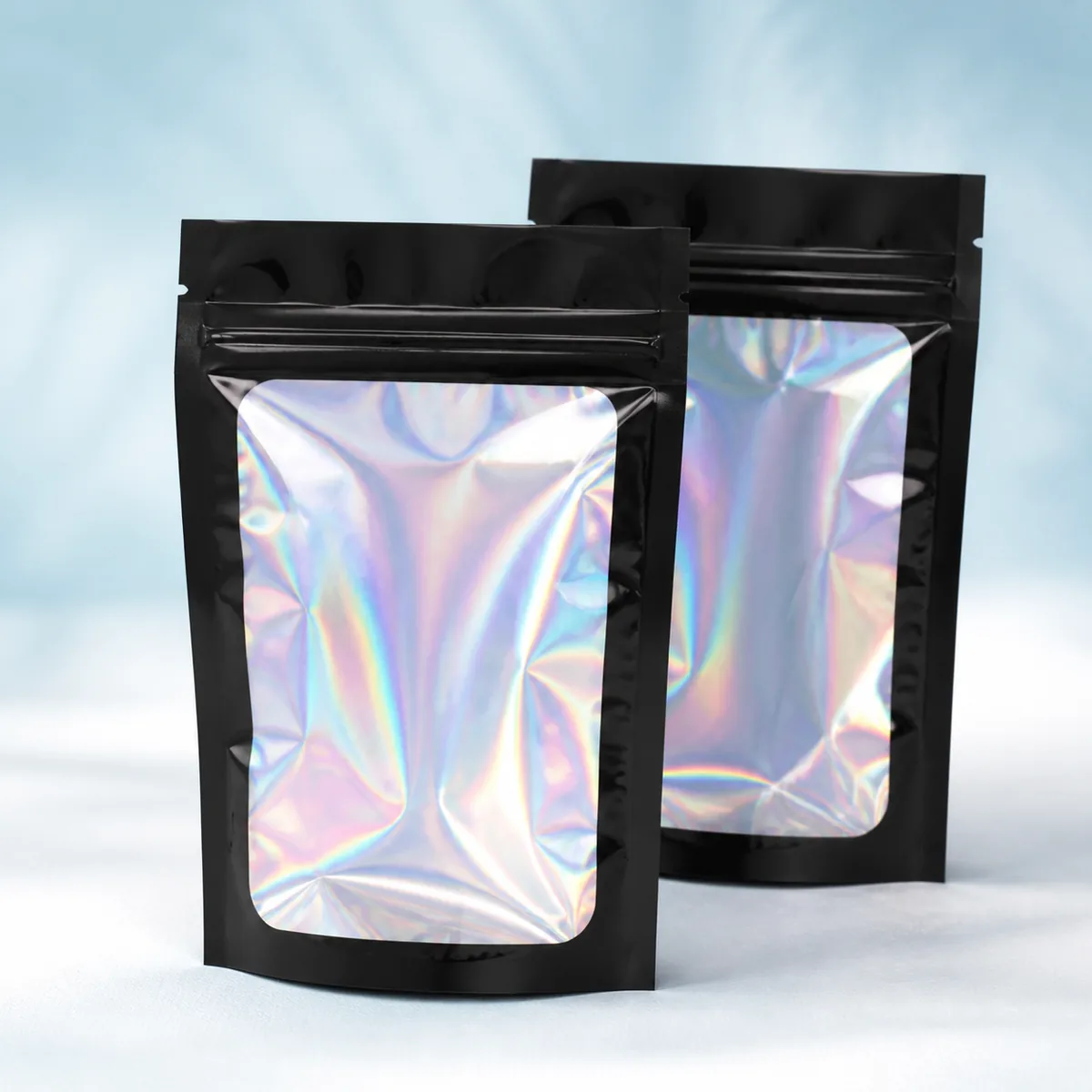 Empty black holographic zipper bags in two sizes.